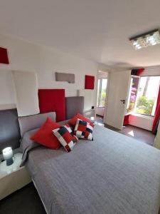 a bedroom with a large bed with red pillows at Le 4 stagioni, appartamento in Villa in Bordighera