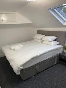 a bedroom with a bed with white sheets and pillows at 2 Bedroom Flat in London in London