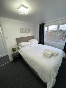 a large white bed in a room with a window at 2 Bedroom Flat in London in London