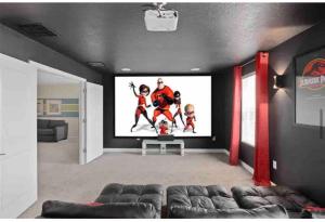 ein Wohnzimmer mit einem Großbildfernseher an der Wand in der Unterkunft Maidstone Villa 8BR Sleeps 16 in Davenport