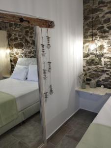 a bedroom with a mirror next to a bed at Karystos Chora Suites in Karistos