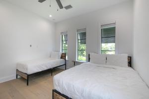 a white bedroom with two beds and windows at Ocean Estate in Fort Pierce