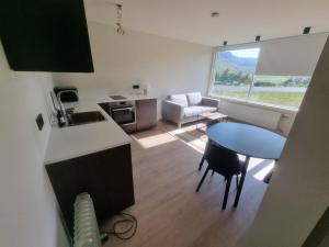 Dúfan Apartments في Bolungarvík: مطبخ وغرفة معيشة مع طاولة وأريكة