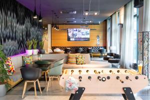 a restaurant with tables and chairs and a bar at Moxy Frankfurt Airport in Frankfurt/Main