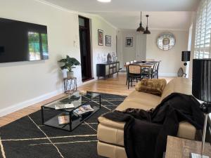 uma sala de estar com um sofá e uma mesa em Middlesex - Your home away from home em Orange
