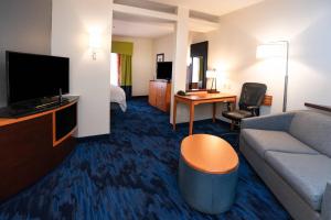 een hotelkamer met een bank en een televisie bij Fairfield Inn & Suites by Marriott Grand Island in Grand Island