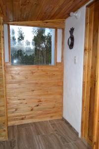 Cette chambre dispose d'une porte en bois et d'une fenêtre. dans l'établissement glamping casa blanca, à Guatavita