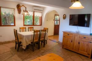 Un comedor con mesa y sillas y un televisor. en Unser traum, en Villa General Belgrano