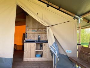 a tent with a kitchen inside of it at Luxury glamping with private bathroom near the Frisian waters in De Veenhoop