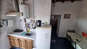 una pequeña cocina con nevera y microondas en Hospedaje Guandacol en Guandacol