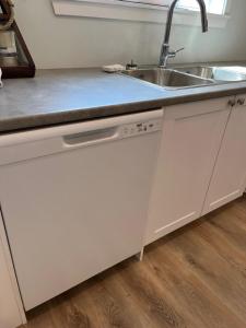 a kitchen with a sink and a counter top at Kwalikum Kottage in Qualicum Beach