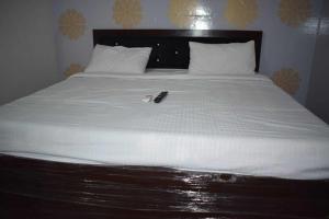 a white bed with a phone sitting on top of it at OYO As Hotel And Restaurant Unit 2 in Meerut
