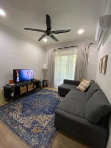 a living room with a couch and a flat screen tv at Homestay Hana Senawang in Seremban