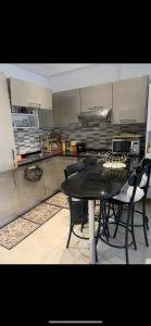 a kitchen with a black table and chairs at Appartement Résidence Palm Lake Monastir in Monastir