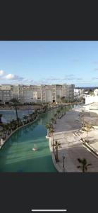 a body of water with palm trees and a beach at Appartement Résidence Palm Lake Monastir in Monastir