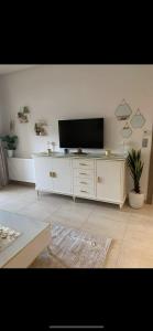 a living room with a television on a white cabinet at Appartement Résidence Palm Lake Monastir in Monastir