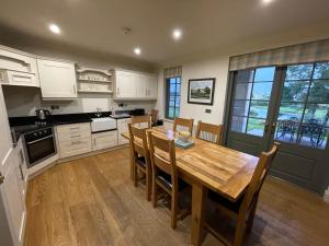 a kitchen with a wooden table and chairs at Lough Erne Fisherman's Cottage in Enniskillen