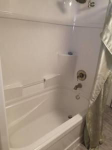 eine weiße Badewanne im Bad in der Unterkunft BEACHFRONT Inn in North Bay
