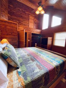 a bedroom with a bed in a wooden cabin at Chalet with a view at Bear Mountain - Hottub in Eureka Springs