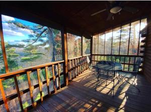 a screened in porch with a table and chairs on it at Chalet with a view at Bear Mountain - Hottub in Eureka Springs