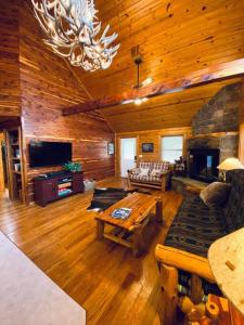 a living room with a couch and a table in a cabin at Chalet with a view at Bear Mountain - Hottub in Eureka Springs