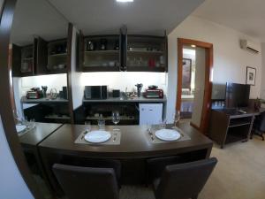 una cocina con una isla grande con 2 mesas de comedor en Bonaparte Hotel - Excelente Apartamento #1402 en Brasilia