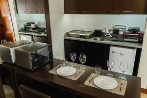 una cocina con una mesa con dos platos y copas de vino en Bonaparte Hotel - Excelente Apartamento #1402 en Brasilia