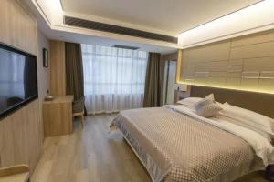 a hotel room with a bed and a flat screen tv at Morninginn, Chenzhou Guiyang in Guiyang