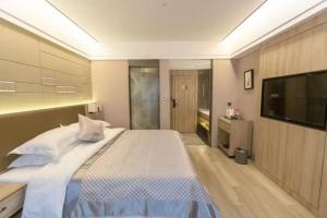 a bedroom with a large bed and a flat screen tv at Morninginn, Chenzhou Guiyang in Guiyang