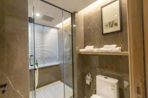 Un baño con ducha de cristal y un inodoro. en Morninginn, Chenzhou Guiyang, en Guiyang 18 fotos más