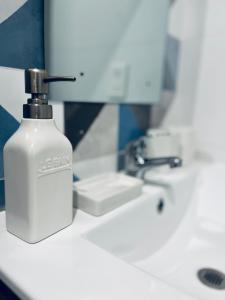 a white bottle of soap sitting on a bathroom sink at Loft céntrico San borja - San Isidro in Lima