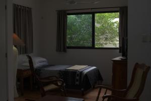 une chambre avec un lit, une table et une fenêtre dans l'établissement La Casa del Chac, à Mérida