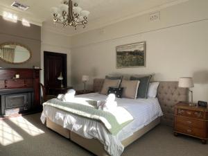 Un dormitorio con una cama con sábanas blancas y una lámpara de araña. en Middlesex - Your home away from home en Orange