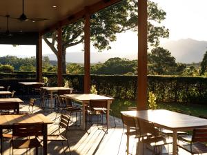 a patio with tables and chairs and a view of the mountains at The Lodge Bellingen in Bellingen