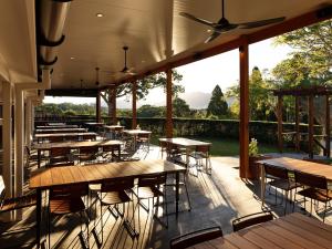 a restaurant with tables and chairs on a deck at The Lodge Bellingen in Bellingen