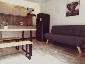 a living room with a couch and a table and a refrigerator at Apartamento en Medellín-clínica las Americas in Medellín
