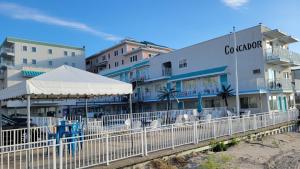 a building on the beach with a white fence at Conca D'or Motel in Wildwood Crest