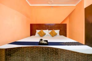 a bedroom with a large bed with orange walls at SPOT ON Hotel New Style in Zirakpur