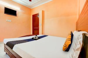 a bedroom with a white bed with orange walls at SPOT ON Hotel New Style in Zirakpur