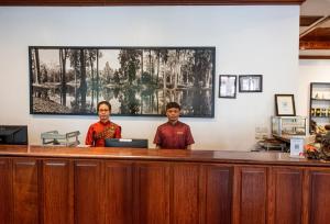 two people standing at a counter in front at Royal Crown Hotel & Spa in Siem Reap