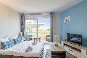 una camera con un grande letto e una TV di Beautiful flat in Les Minimes with balcony and parking in La Rochelle a La Rochelle