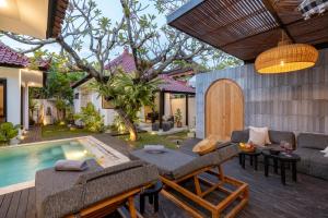 an outdoor patio with a pool and a villa at Zee Design Villa & Spa Sanur in Sanur