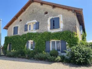 Una casa con hiedra a un lado. en Gîte Le Bouchaud, 5 pièces, 8 personnes - FR-1-489-227, en Le Bouchaud