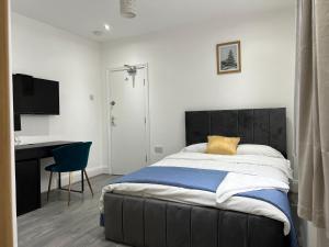 a bedroom with a bed with a desk and a chair at En-suite double room in Wanstead