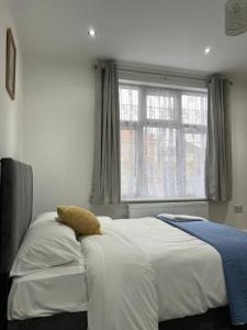 1 dormitorio con 1 cama grande y ventana en En-suite double room, en Wanstead