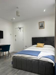 a bedroom with a large bed and a chair at En-suite double room in Wanstead
