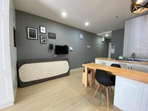 een slaapkamer met een bed, een bureau en een tafel bij A Modern & Homely Studio with Pool and Gym in Kampar