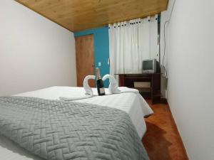 una camera da letto con un letto con cigni sopra di Guaxique a Guasca