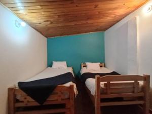 two beds in a room with a wooden ceiling at Casa en Guasca in Guasca