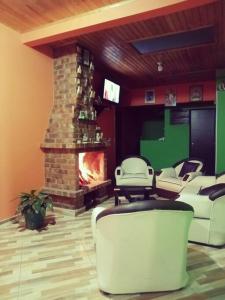 sala de estar con chimenea, sillas y TV en Casa en Guasca en Guasca